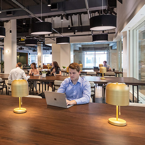 A man works on his laptop in open concept workspace